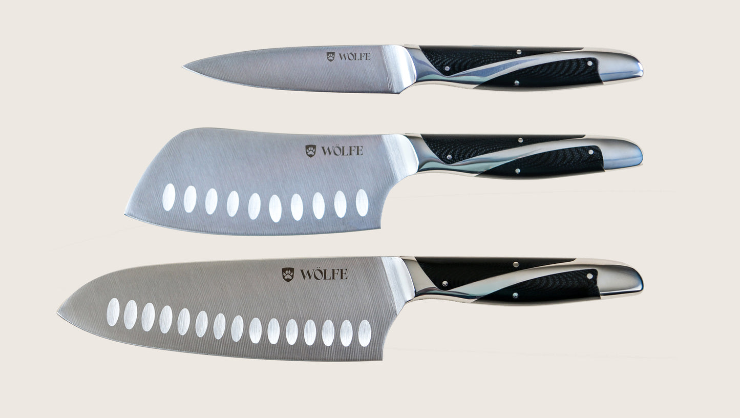 Set of three knives with black handles and visible 'Wolfe' branding on a light background