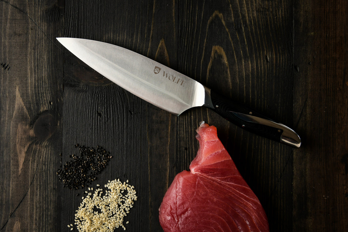 Knife on a wooden surface with raw meat and spices