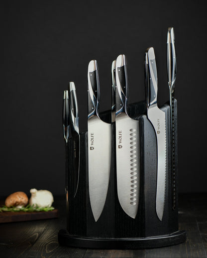 Set of knives in a black holder on a dark background