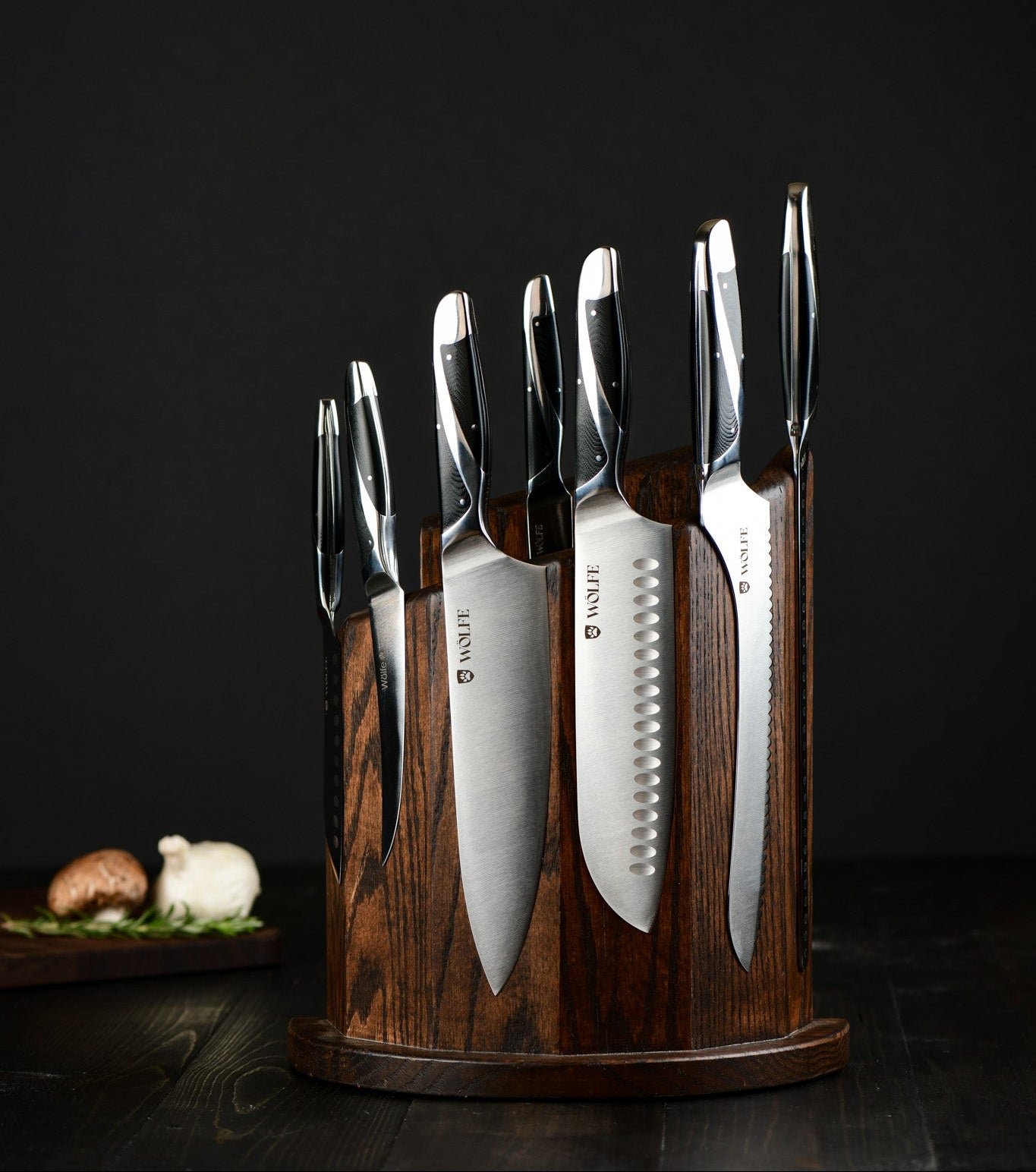 Set of knives in a wooden holder on a dark background