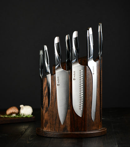 Set of knives in a wooden holder on a dark background