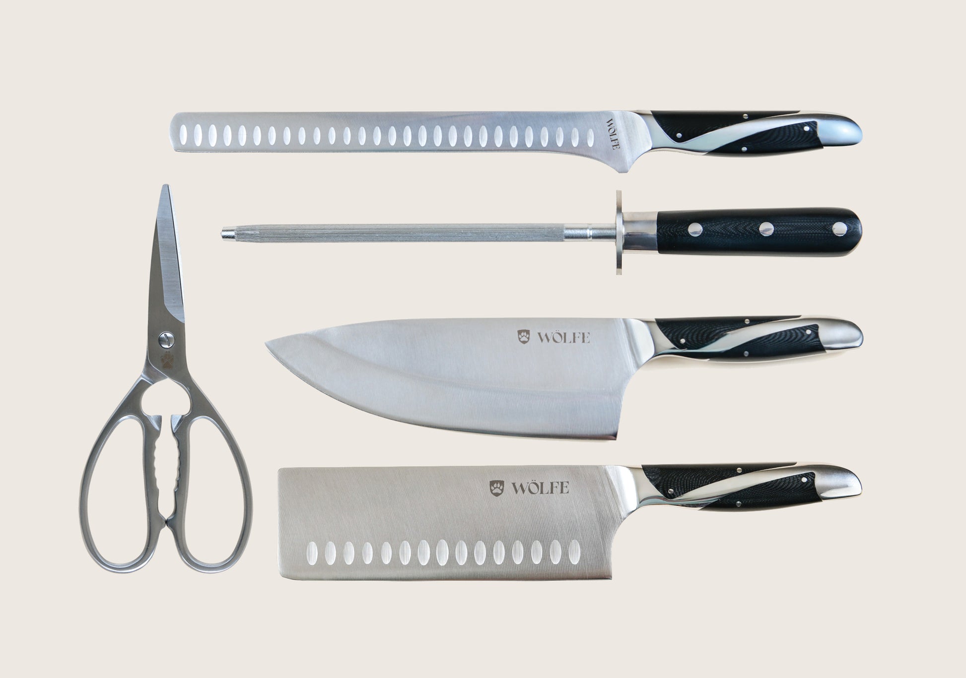 Set of knives and a pair of scissors on a light gray background