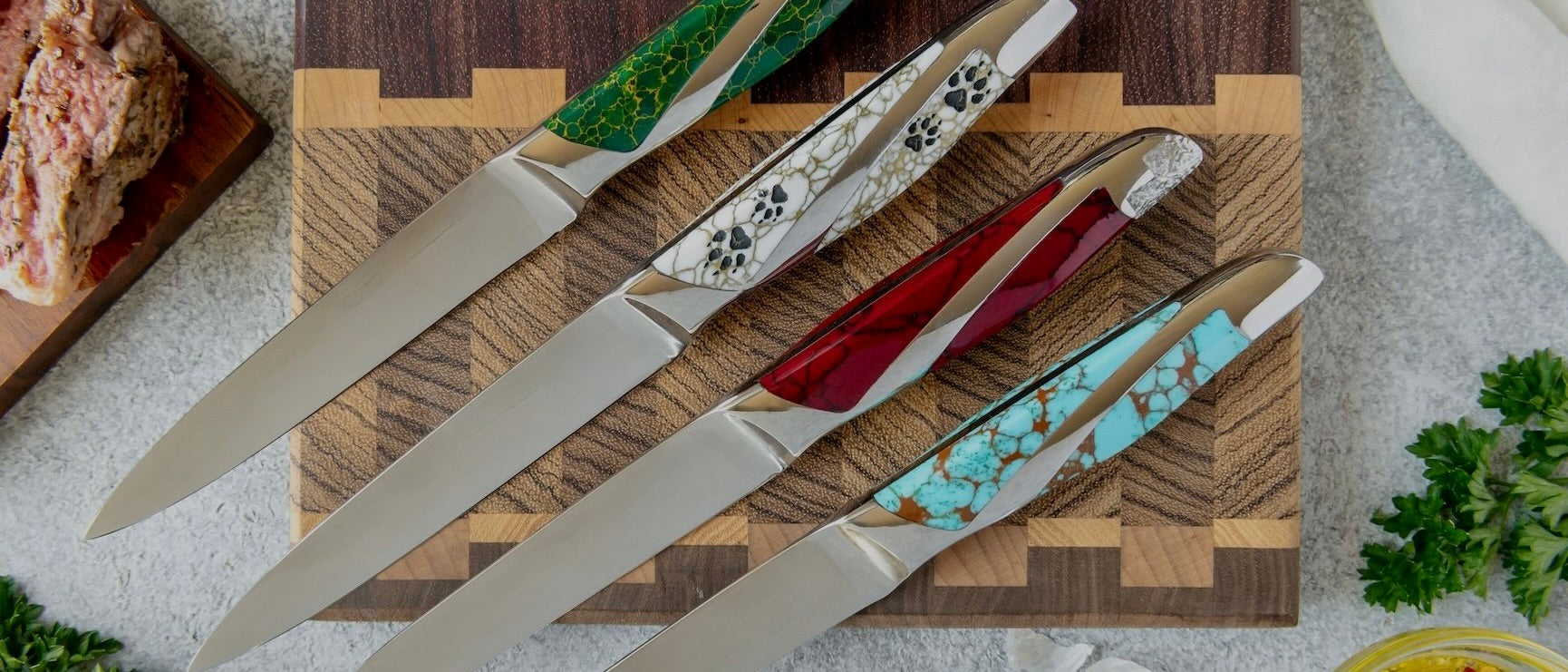 Set of knives with decorative handles on a wooden cutting board