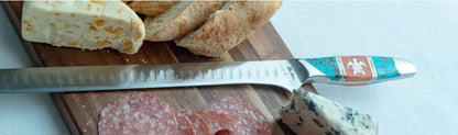 Slicer knife with decorative handle on a cutting board with bread and cheese