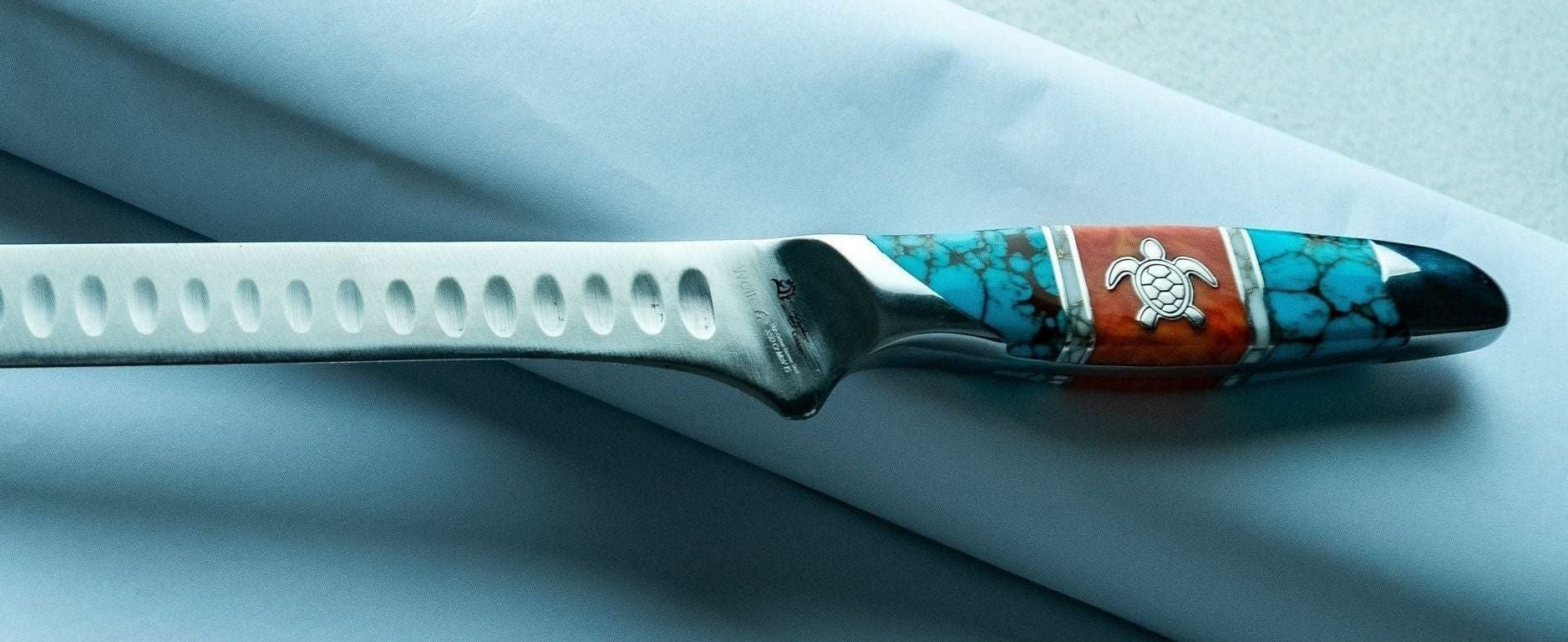 Decorative knife with a turtle design on a white background