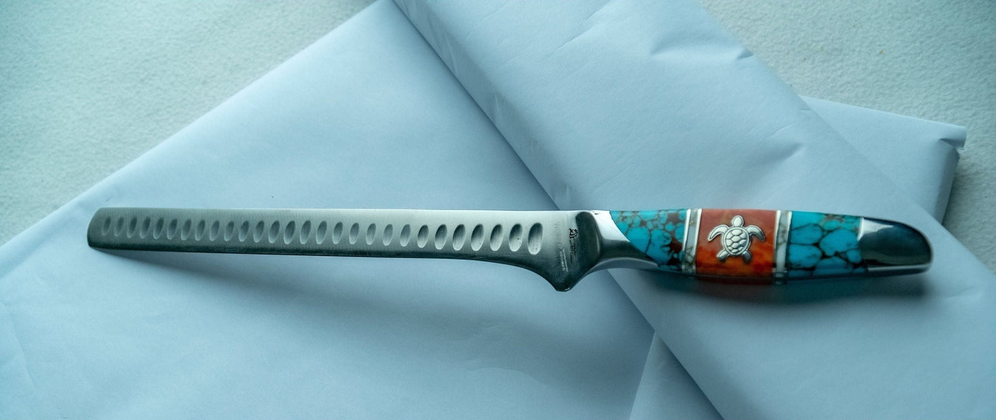 Knife with decorative handle on a light blue fabric background