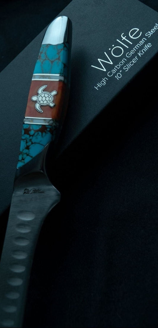 Knife with decorative handle on a black background, featuring the brand 'Wölfe'.