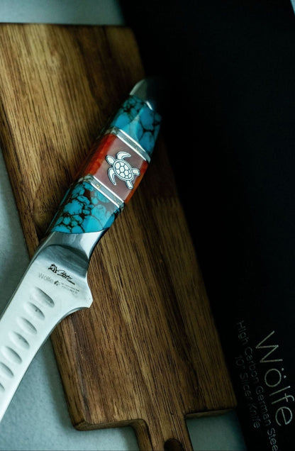 Decorative knife with a turtle design on a wooden cutting board