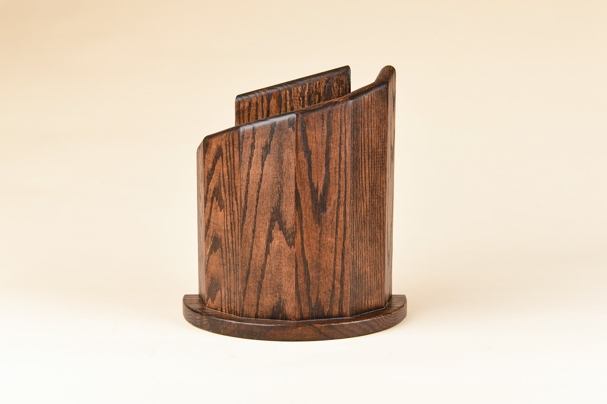 Brown semi-circular wooden knife block on a beige background