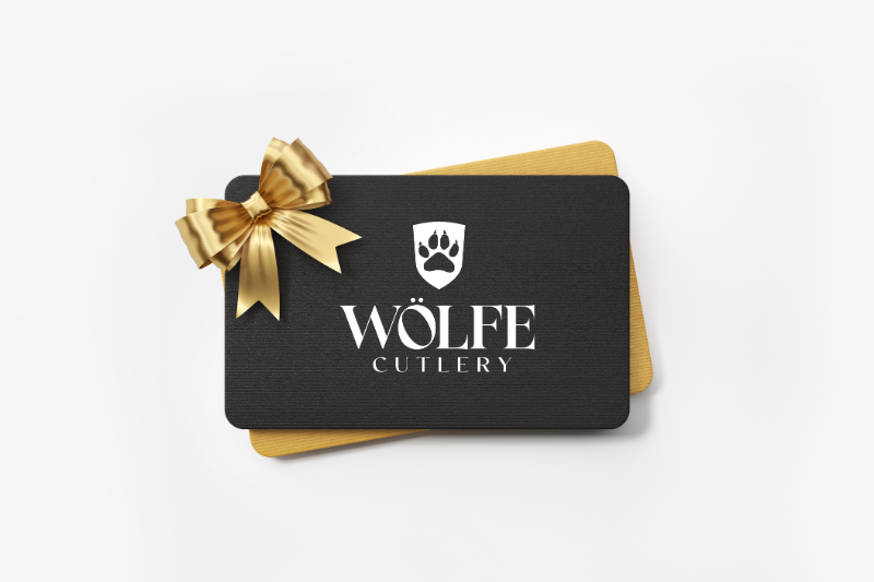 Black gift card with gold bow and 'Wolfe Cutlery' logo on a white background